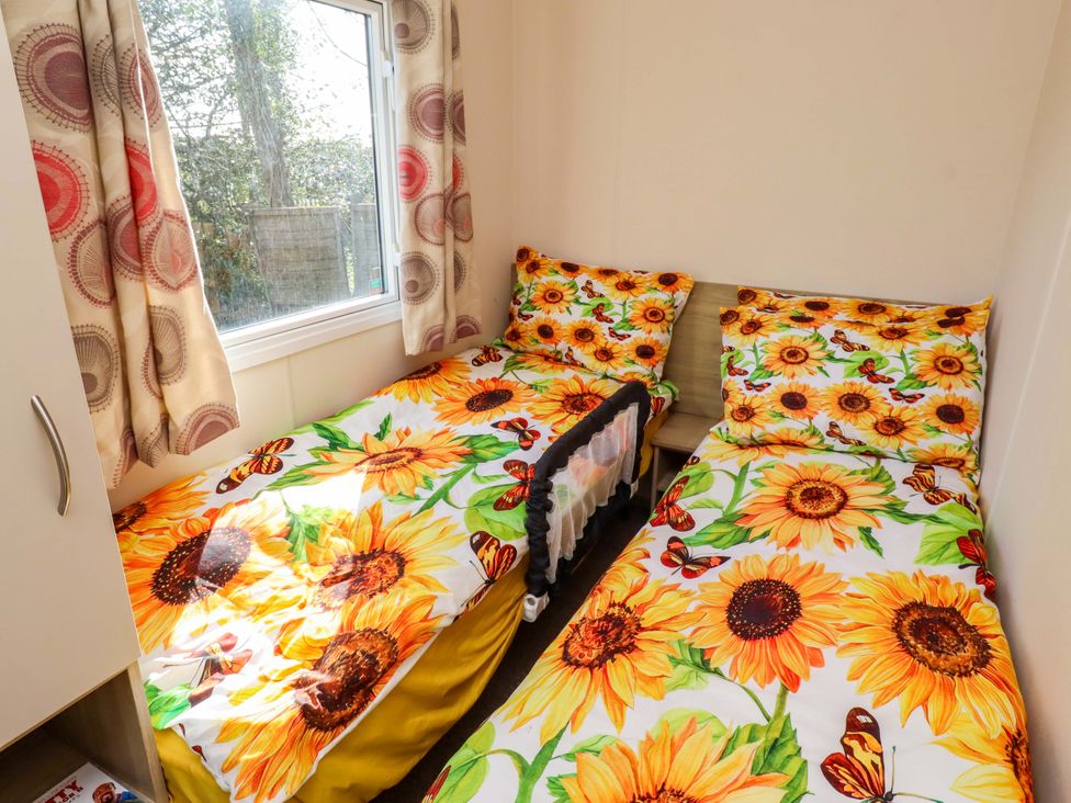 A bedroom with two beds and a window at Sunflower Retreat, Caravan 61