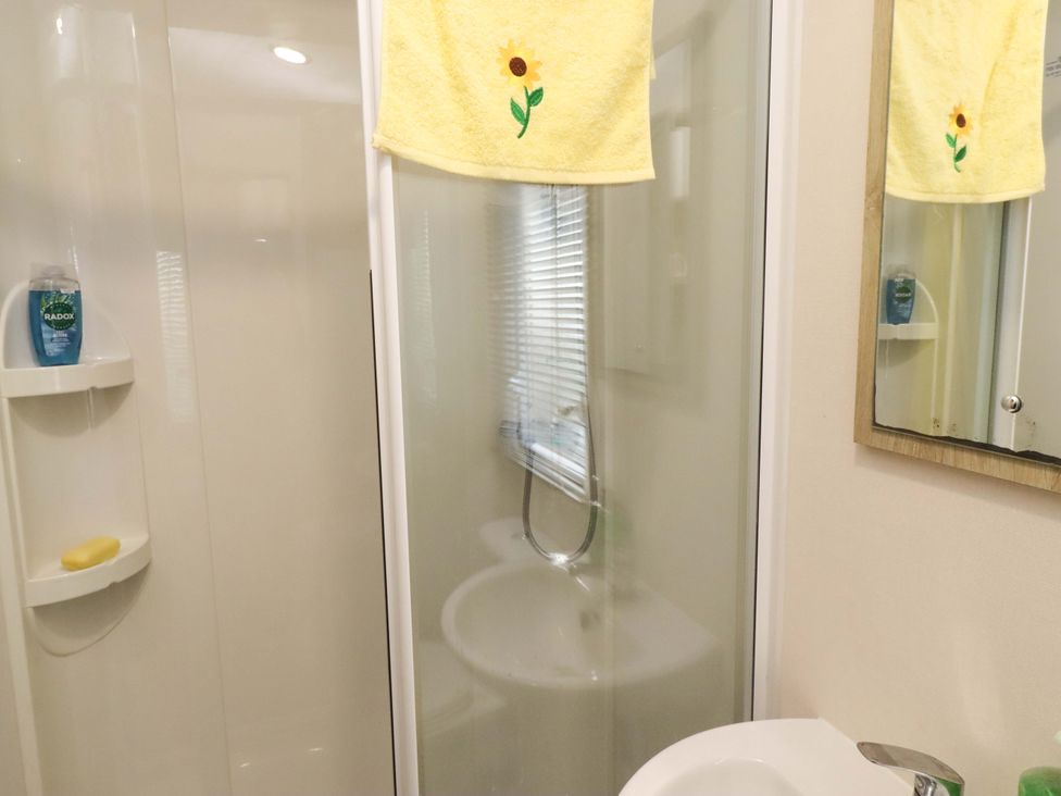 A bathroom with a shower and sink at Sunflower Retreat, Caravan 61