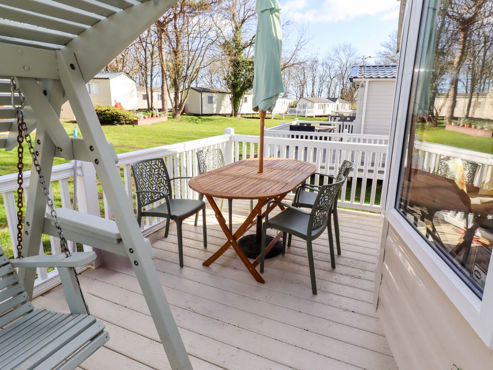 An outdoor seating area with a table and chairs at Sunflower Retreat, Caravan 61