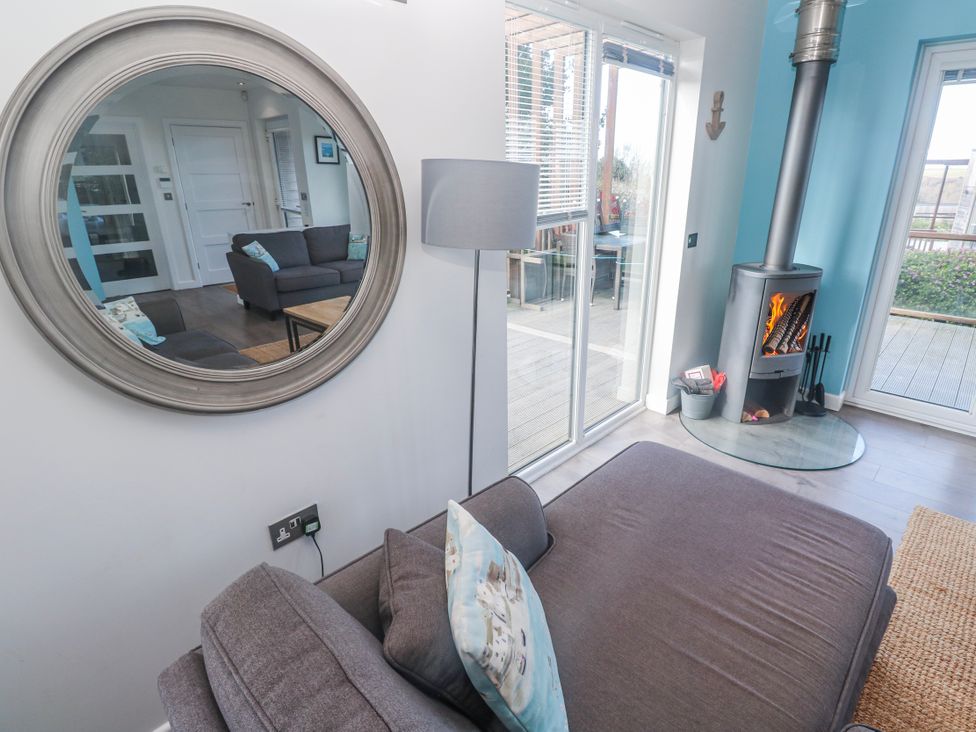 A living room with a sofa and wood stove at Warleggan in Redruth