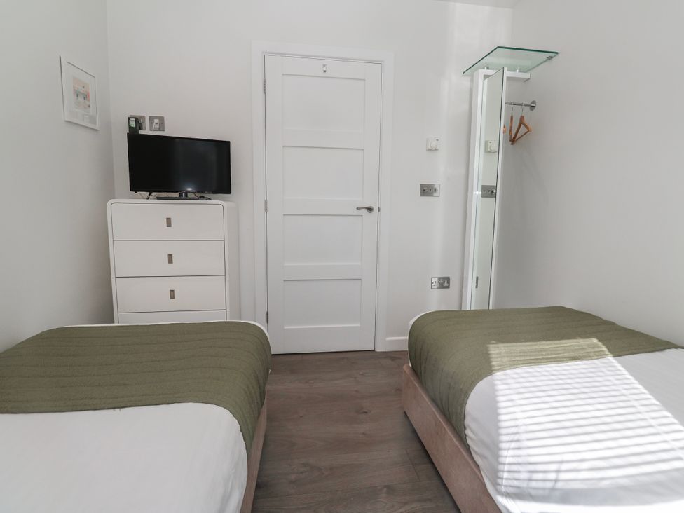 A bedroom with two beds and a television at Warleggan in Redruth