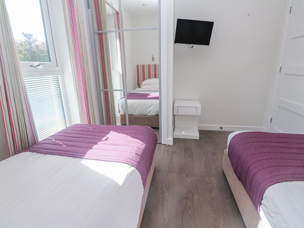 A bedroom with twin beds and a television at Warleggan in Redruth