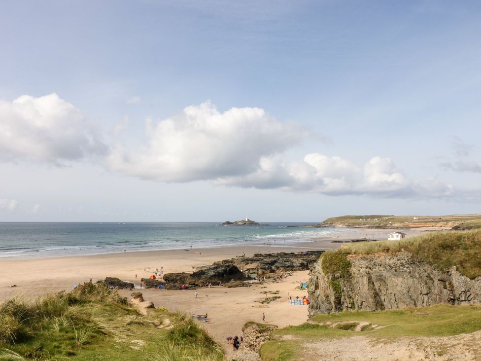 A beach with people and rocks at Warleggan in Portreath