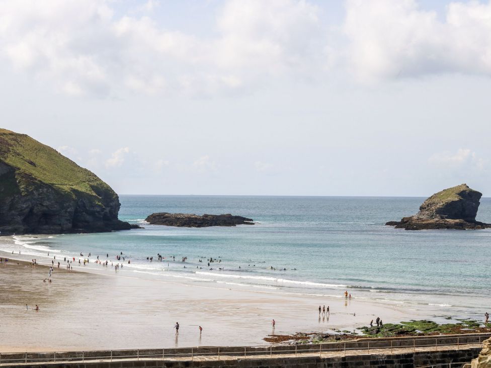 A beach scene with people swimming and walking at Warleggan in Portreath