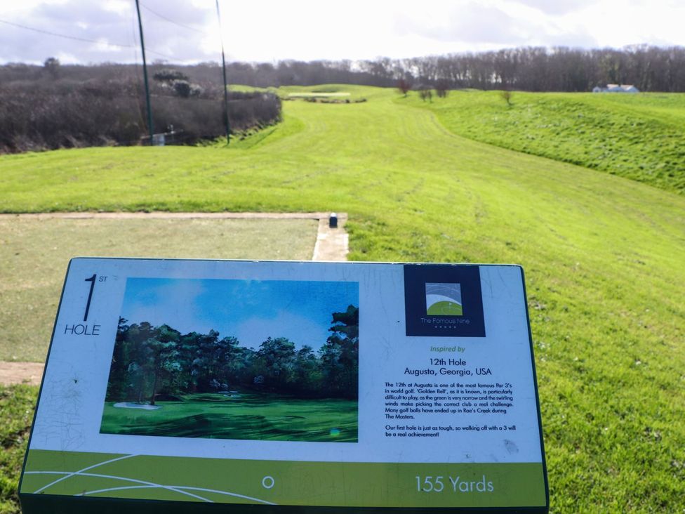 A golf course hole view with a sign at The Famous Nine in Portreath