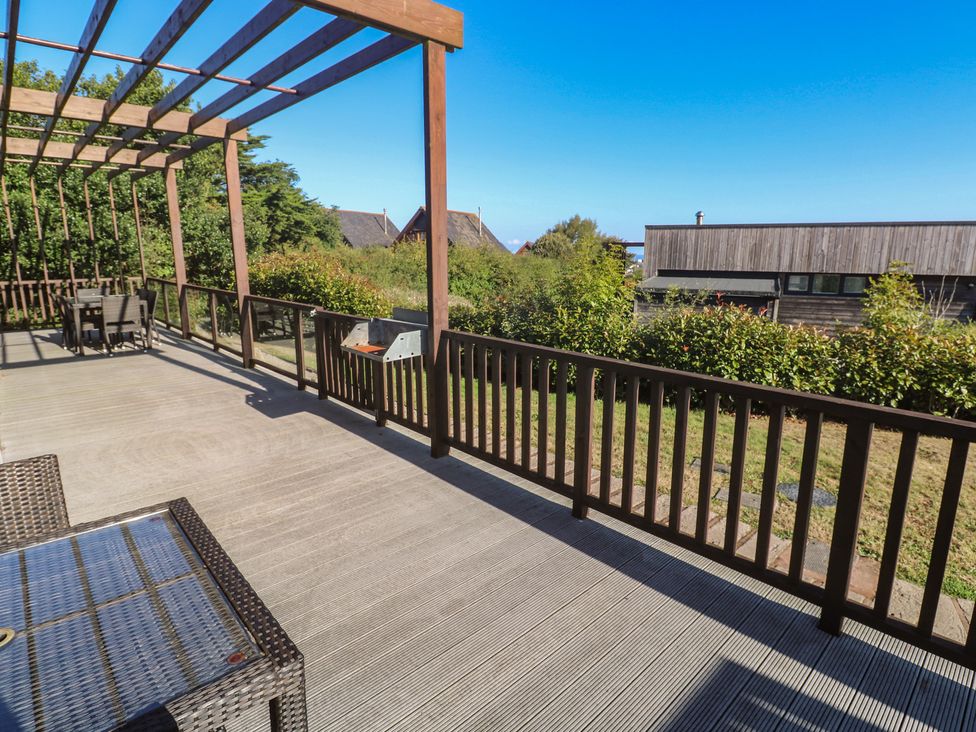 An outdoor deck with a table and chairs at Warleggan in Portreath