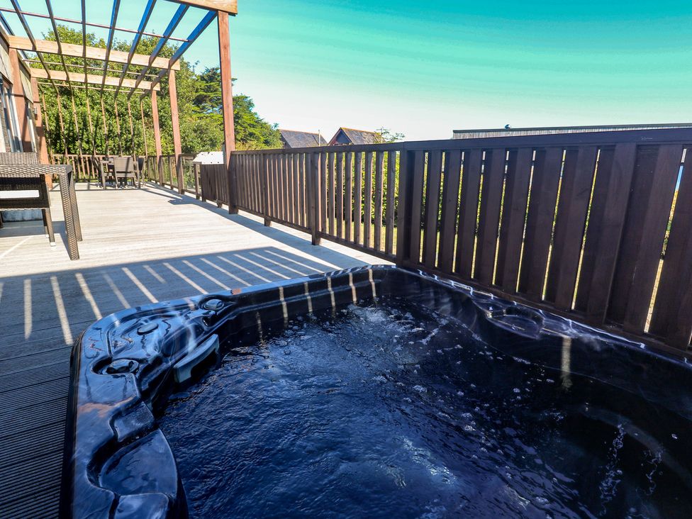 A patio with a hot tub and outdoor furniture at Warleggan in Portreath