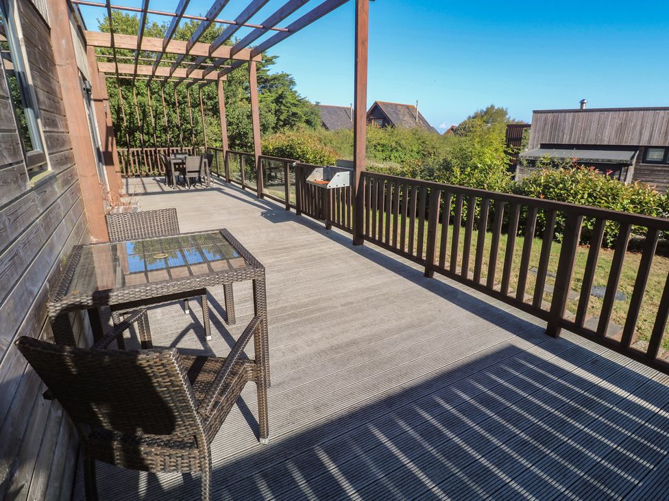 A deck with a table and chair at Warleggan in Portreath