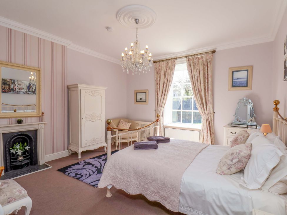 A bedroom with a bed and chandelier at Annie's Place in Sleights