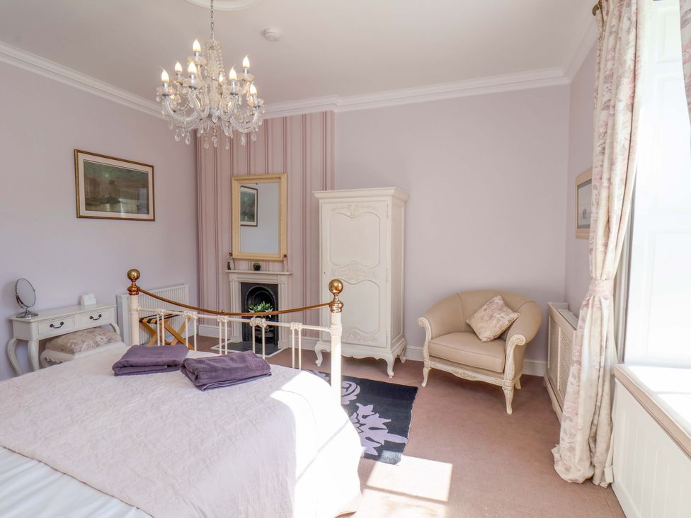 A bedroom with a bed and chandelier at Annie's Place in Sleights