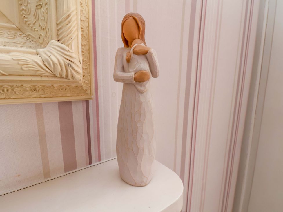 A figurine on a shelf next to a framed picture at Annie's Place in Sleights