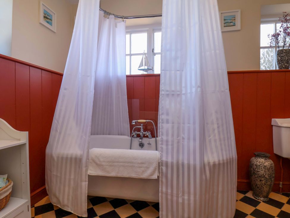 A bathroom with a bathtub and shower curtains at Annie's Place in Sleights