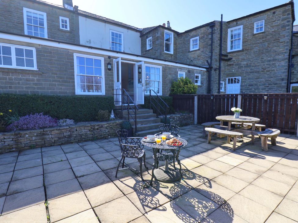 An outdoor seating area with a table and chairs at Annie's Place in Sleights