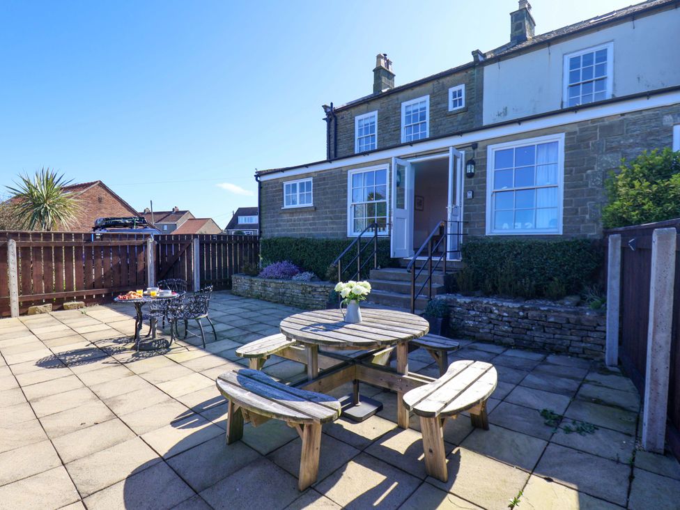 A patio with a table and chairs at Annie's Place in Sleights
