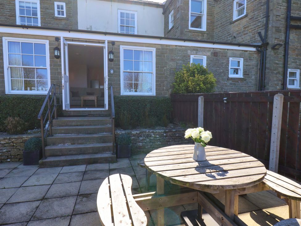 A garden with a wooden table and potted plants at Annie's Place in Sleights