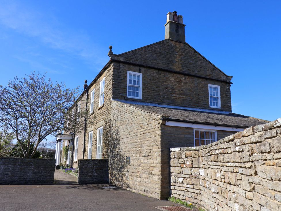 A house with stone wall and tree at Annie's Place in Sleights