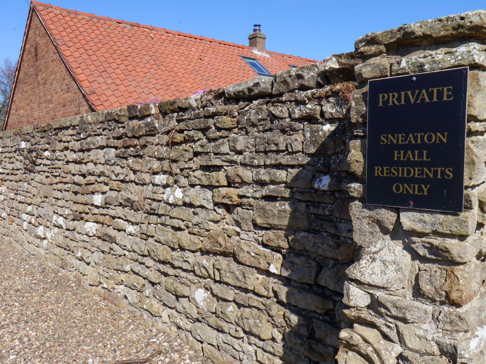 A stone wall with a sign saying private at Sneaton Hall in Sleights