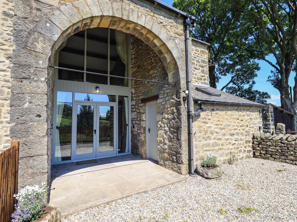 An entrance with glass doors and stone walls at Ragged Hall Barn Settle