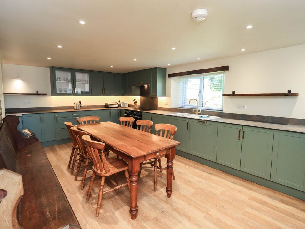 A kitchen with a wooden table and chairs at Ragged Hall Barn Settle
