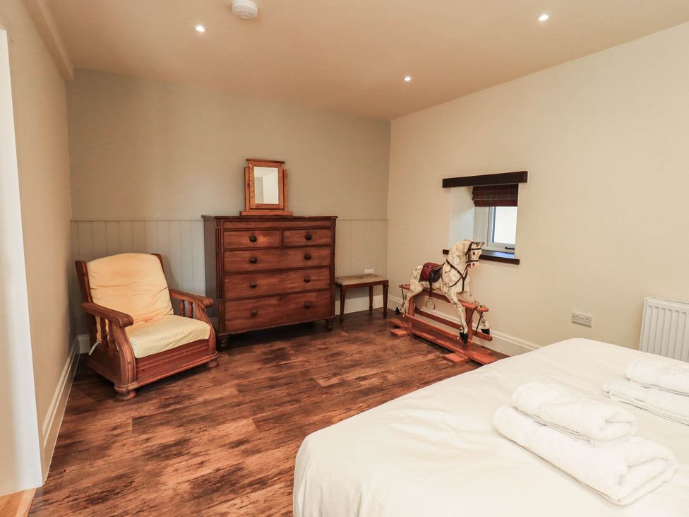 A bedroom with a rocking horse and dresser at Ragged Hall Barn in Settle
