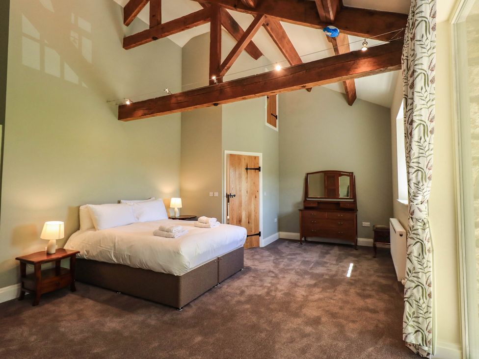 A bedroom with a bed and a dresser at Ragged Hall Barn Settle