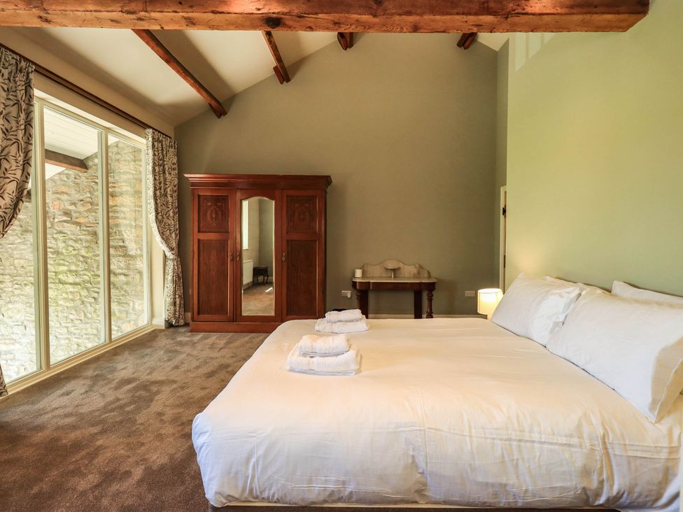 A bedroom with a bed and wardrobe at Ragged Hall Barn Settle