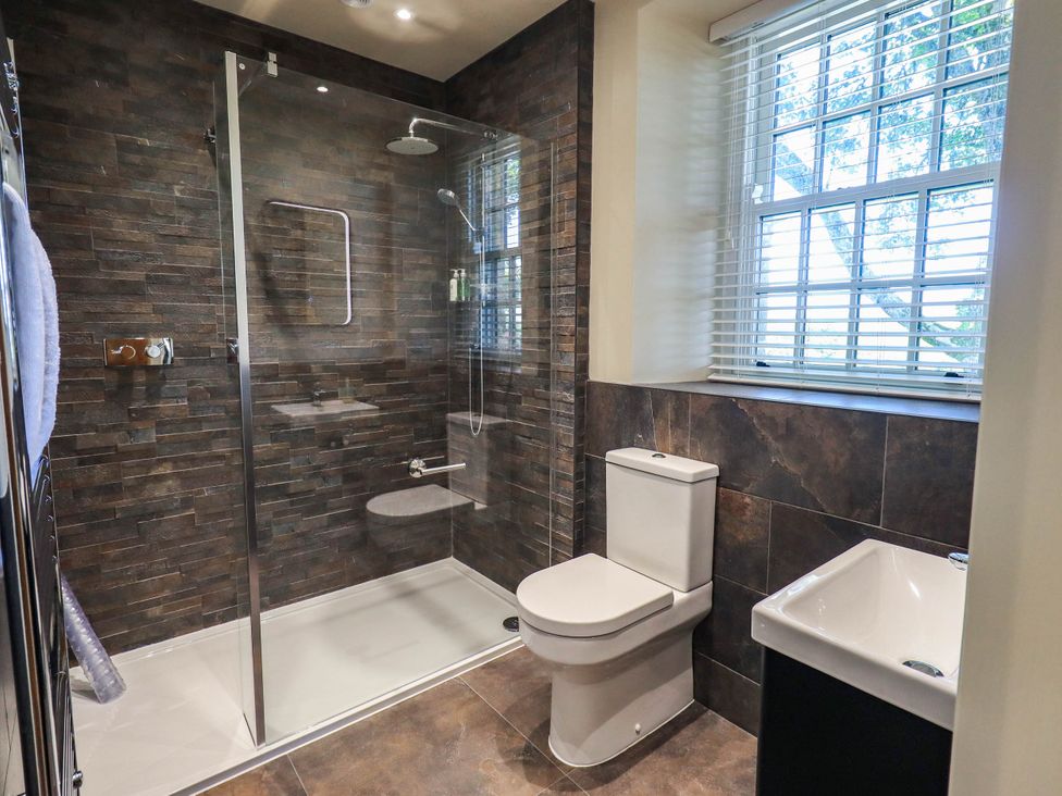 A bathroom featuring a shower, toilet, and sink at Ragged Hall Barn in Settle