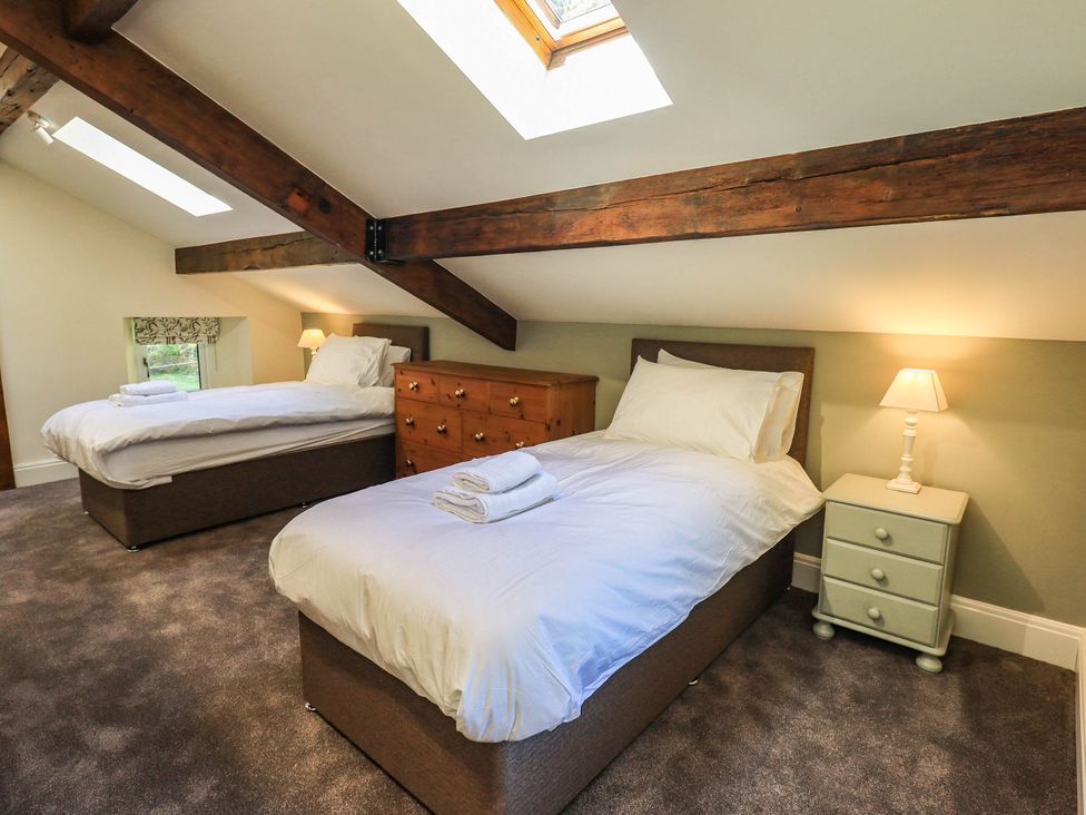 A bedroom with two beds and a dresser at Ragged Hall Barn Settle