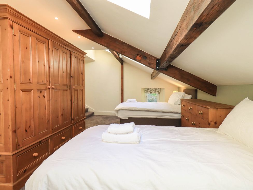 A bedroom with beds and a wardrobe at Ragged Hall Barn Settle