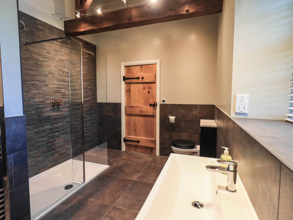 A bathroom with a bathtub and shower at Ragged Hall Barn Settle