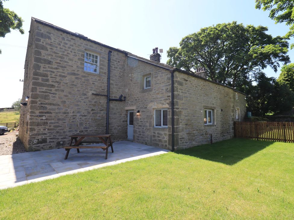 A house with a patio and table in a garden at Ragged Hall Barn Settle