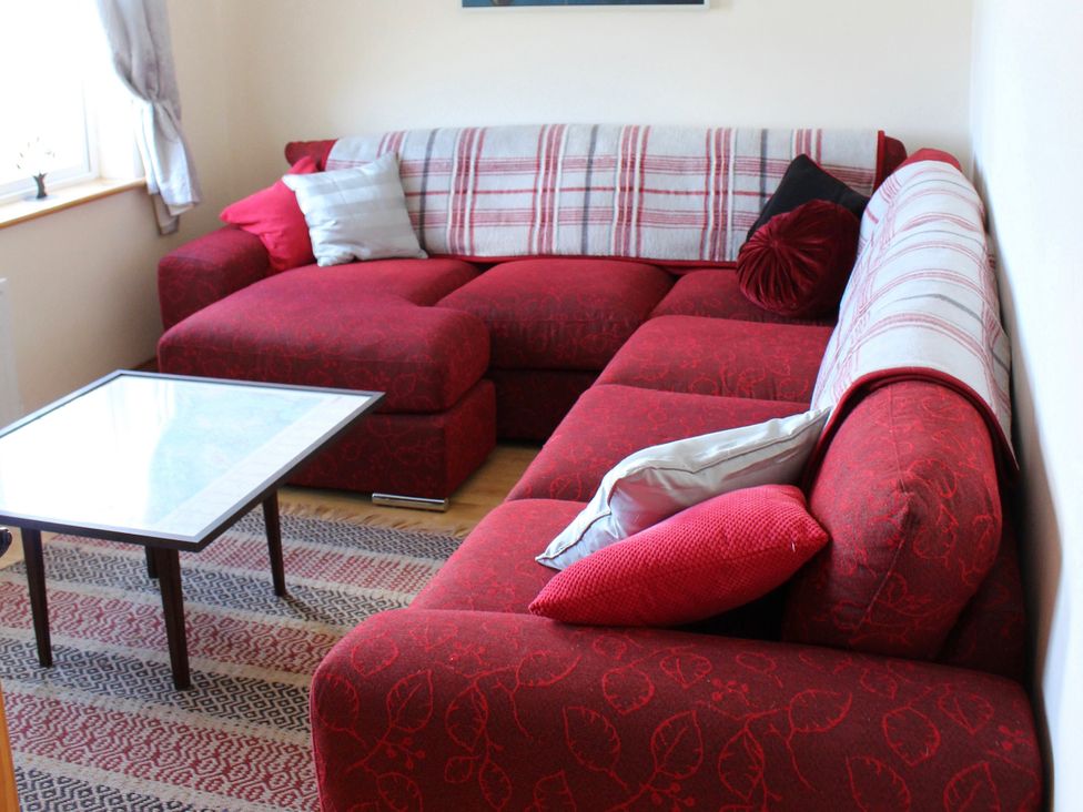 A living room with a red sofa and a coffee table at Welcome to the wild Atlantic way, Mulroy Bay