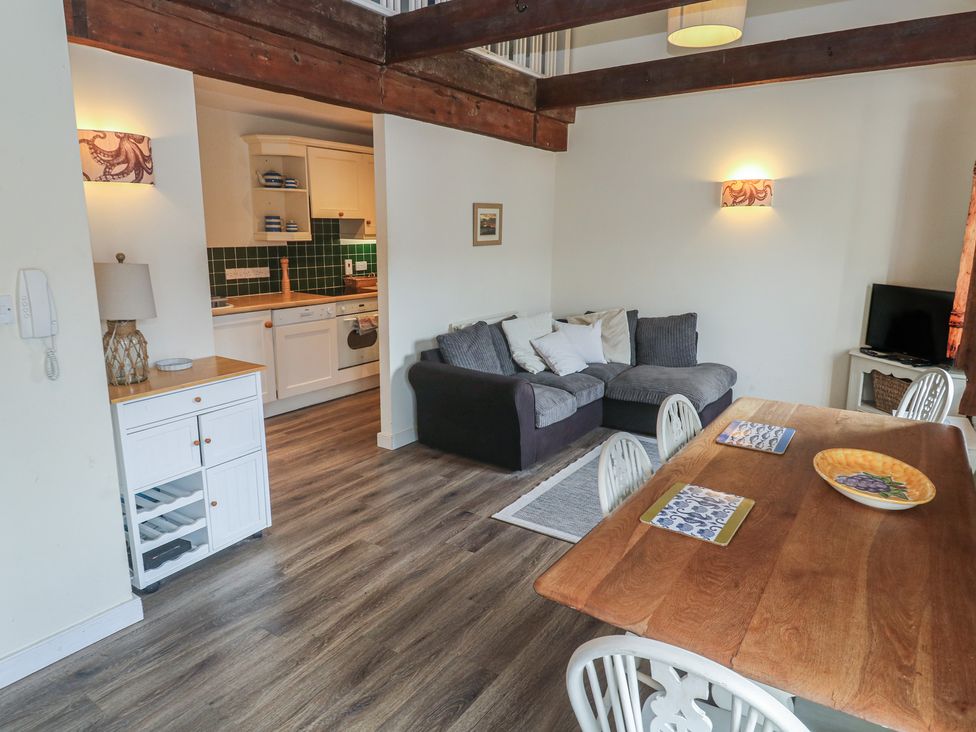 A living room with a sofa and dining table at Apartment 6 in Penryn
