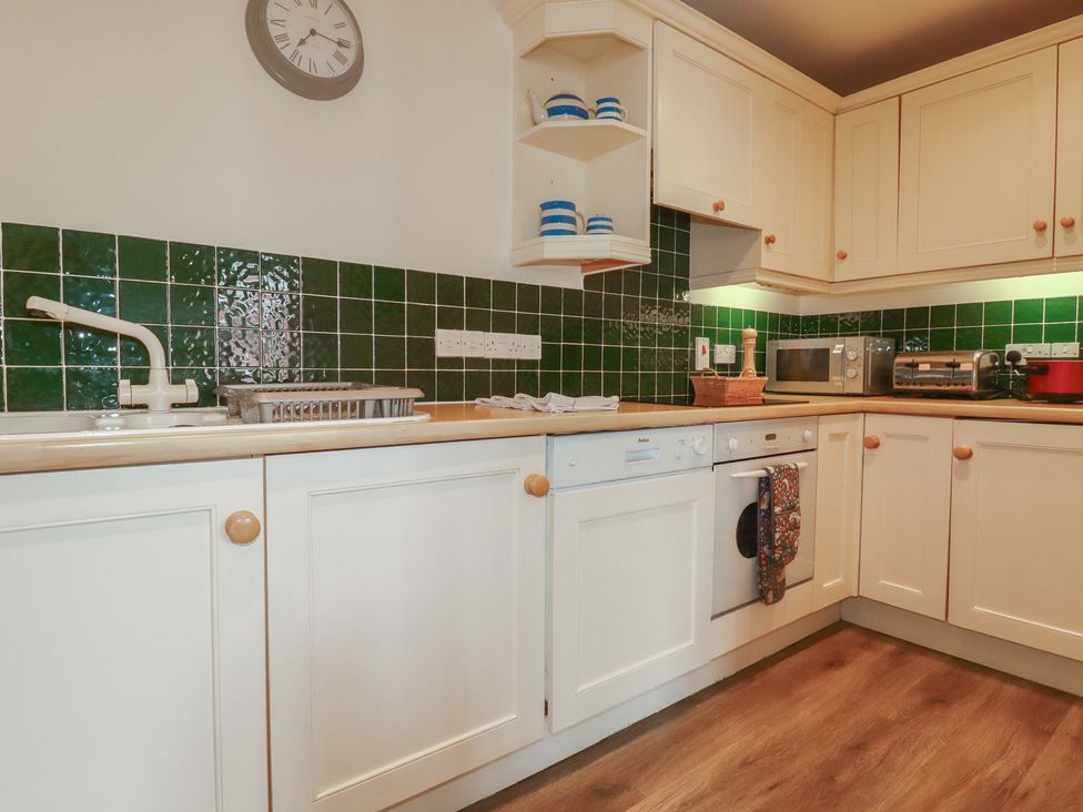 A kitchen with cabinets and appliances at Daniel’s Sail Loft Penthouse in Penryn
