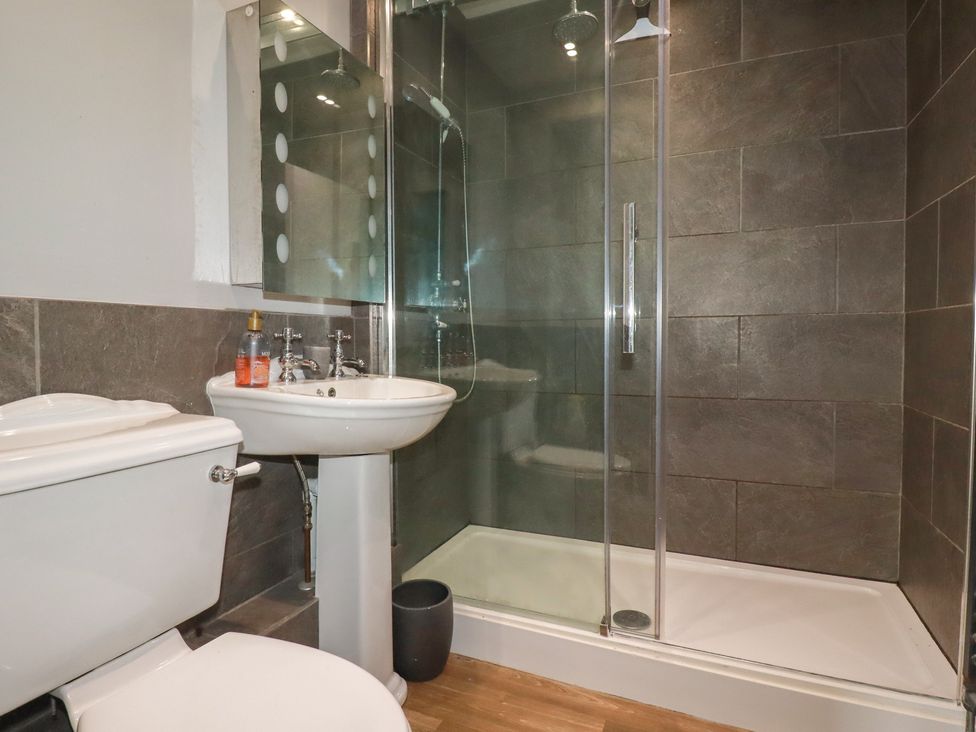 A bathroom with a toilet, sink, and shower at Daniel’s Sail Loft Penthouse in Penryn