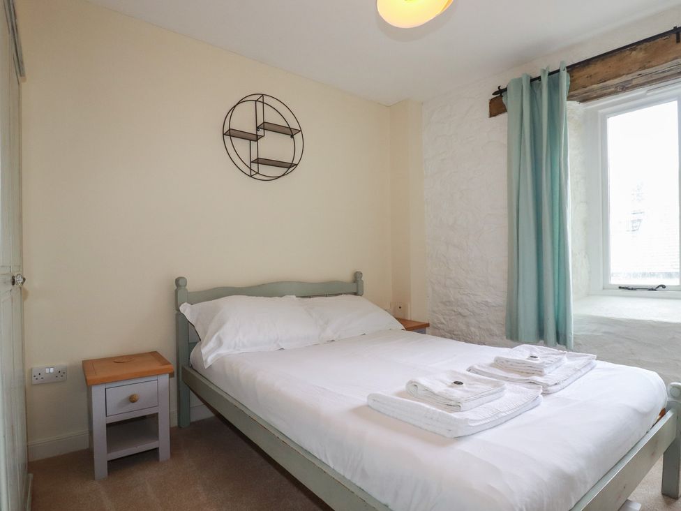 A bedroom with a bed and nightstand at Daniel’s Sail Loft Penthouse in Penryn