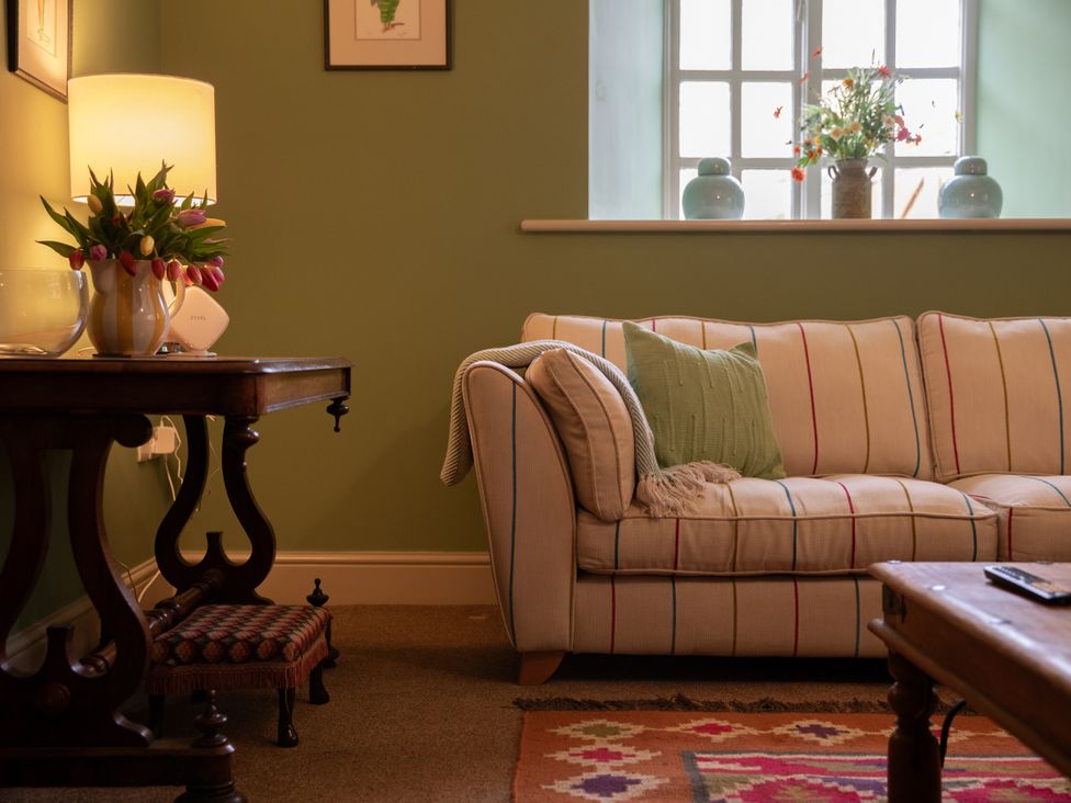 A living room with a sofa and lamp at Bishop Lightfoot Cottage in Bishop Auckland