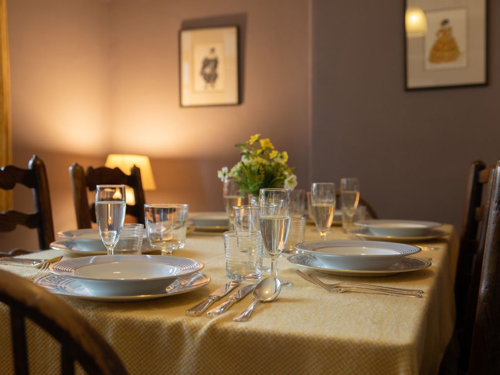 A dining table set with plates and glasses at Bishop Lightfoot Cottage in Bishop Auckland