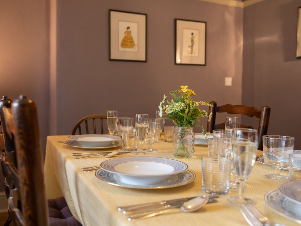 A dining room with a set table and flower vase at Bishop Lightfoot Cottage in Bishop Auckland