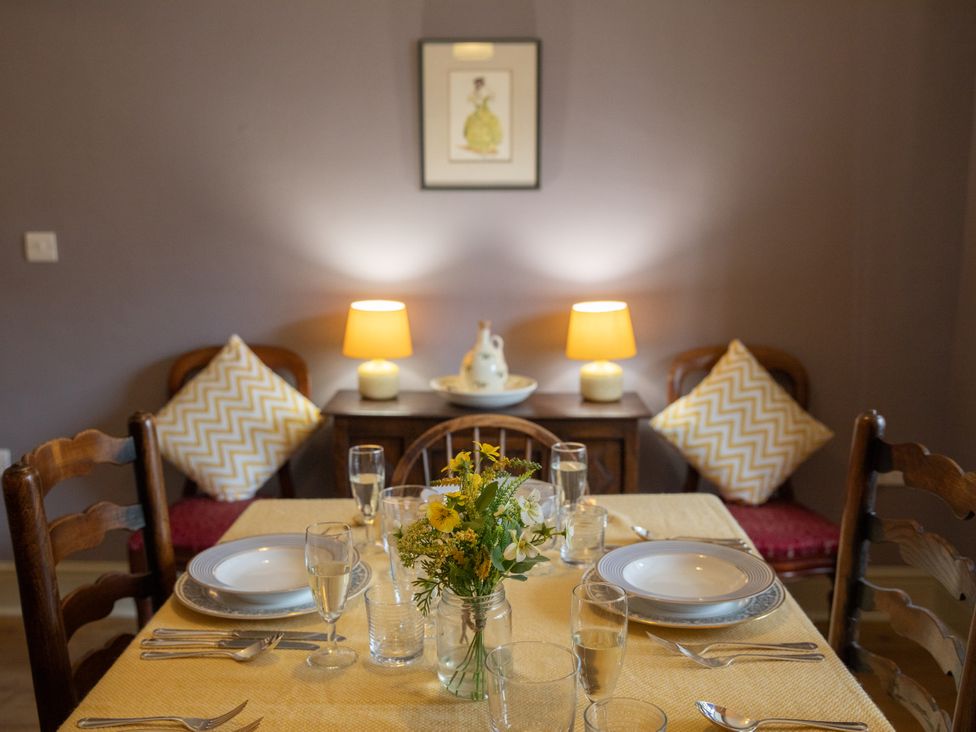 A dining table set with plates and glasses at Bishop Lightfoot Cottage in Bishop Auckland