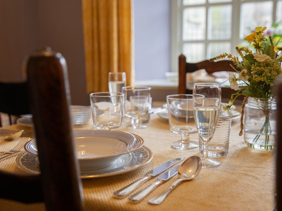A dining table with dishes and glasses at Bishop Lightfoot Cottage in Bishop Auckland
