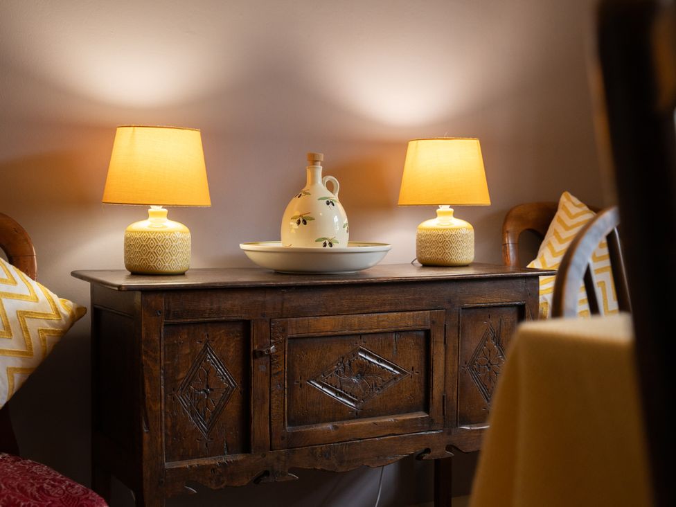 A wooden cabinet with lamps and decorative items at Bishop Lightfoot Cottage in Bishop Auckland