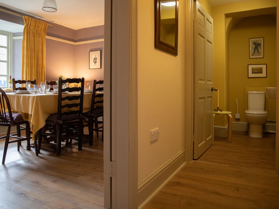 A dining room with a table set for dinner and a bathroom in Bishop Lightfoot Cottage, Bishop Auckland