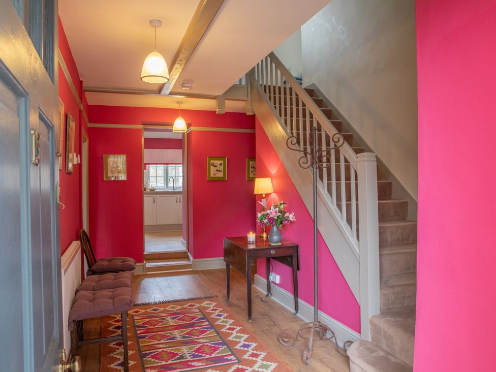 A hallway with a staircase and table at Bishop Lightfoot Cottage in Bishop Auckland