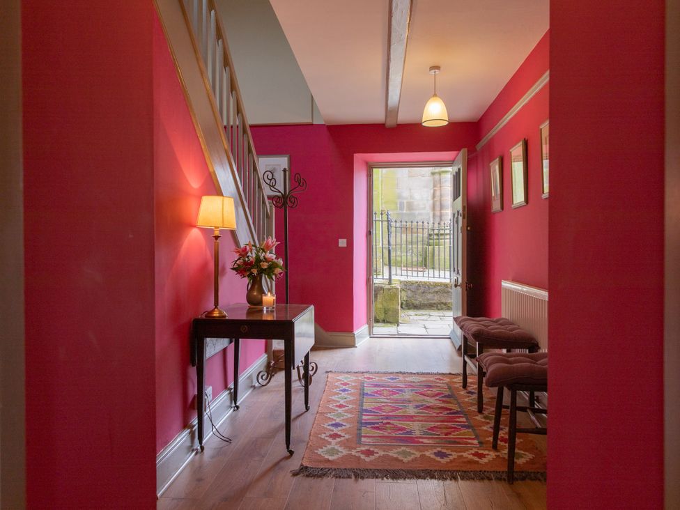 A hallway with a lamp and table at Bishop Lightfoot Cottage in Bishop Auckland