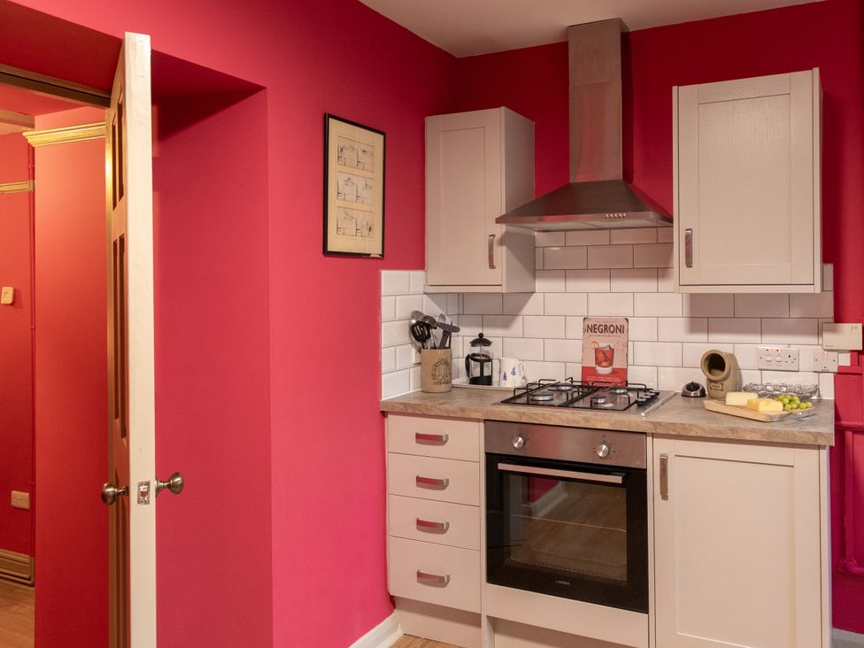 A kitchen with a gas stove and cabinets at Bishop Lightfoot Cottage in Bishop Auckland