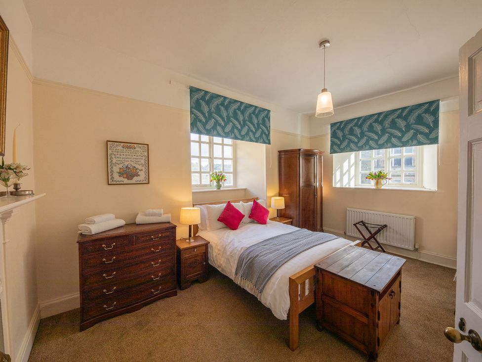 A bedroom with a bed and a wardrobe at Bishop Lightfoot Cottage in Bishop Auckland