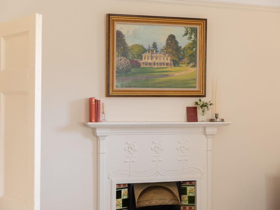 A living room with a fireplace and painting at Bishop Lightfoot Cottage in Bishop Auckland