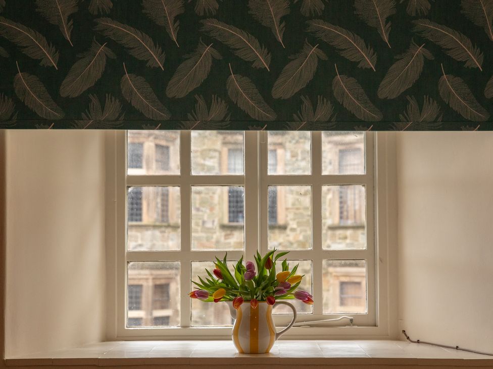 A window with a flower vase on the sill at Bishop Lightfoot Cottage in Bishop Auckland