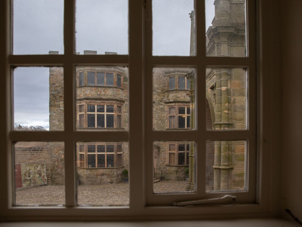 A view from a window showing a stone building courtyard at Bishop Lightfoot Cottage in Bishop Auckland